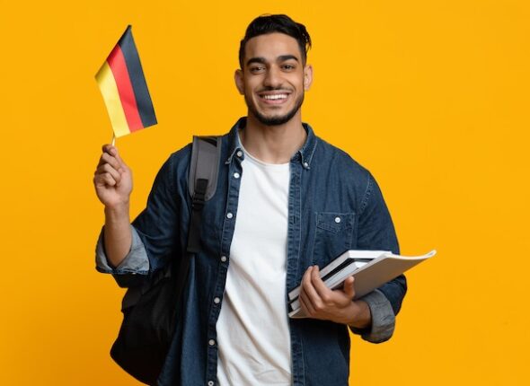 Happy arabic guy student showing flag of Germany