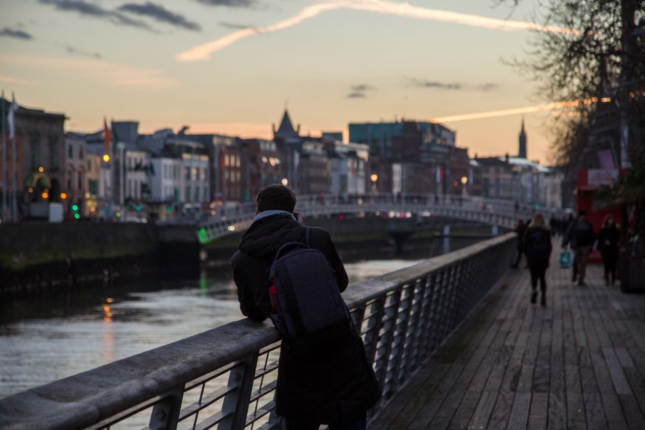 Student looking over Dublin's Ha'penny Bridge at dusk